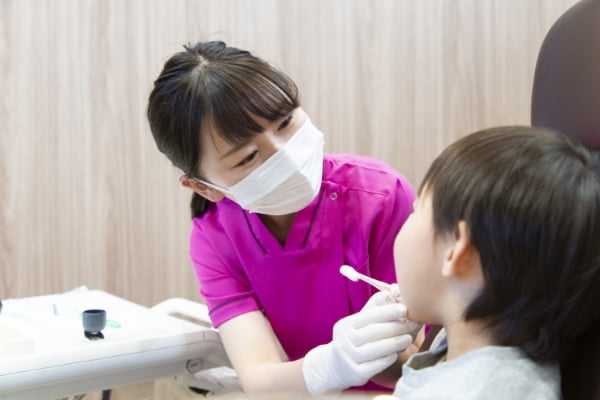歯科衛生士が子供に歯磨きをしている様子